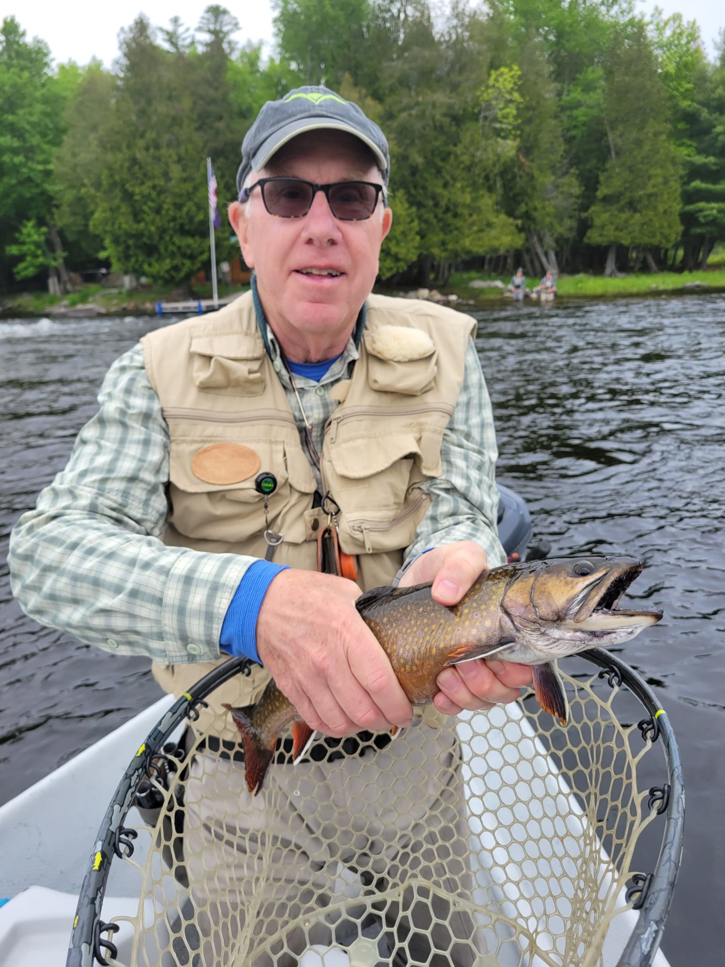 Man standing in boat holding a fish