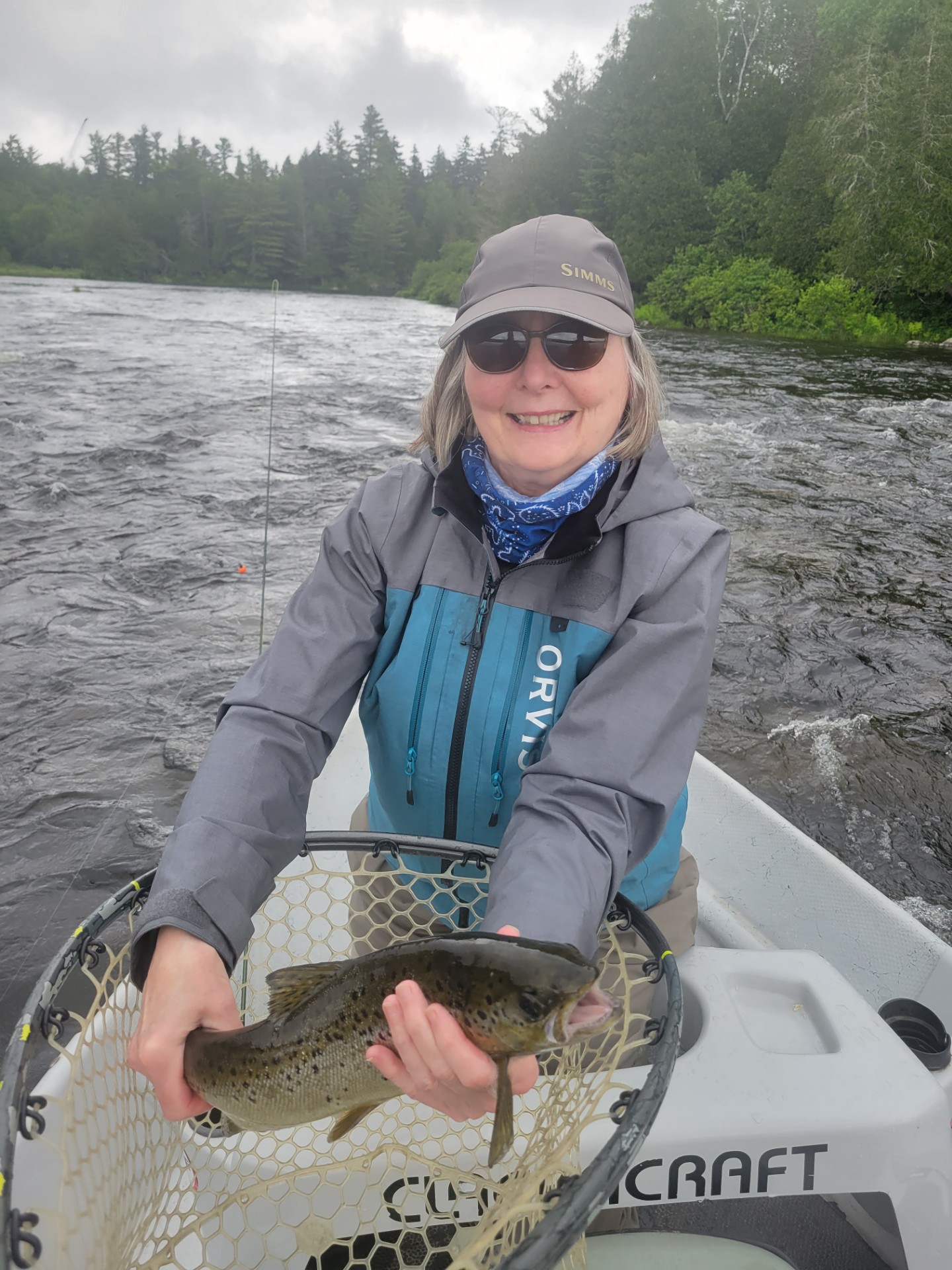 Woman standing in boat holding a fish