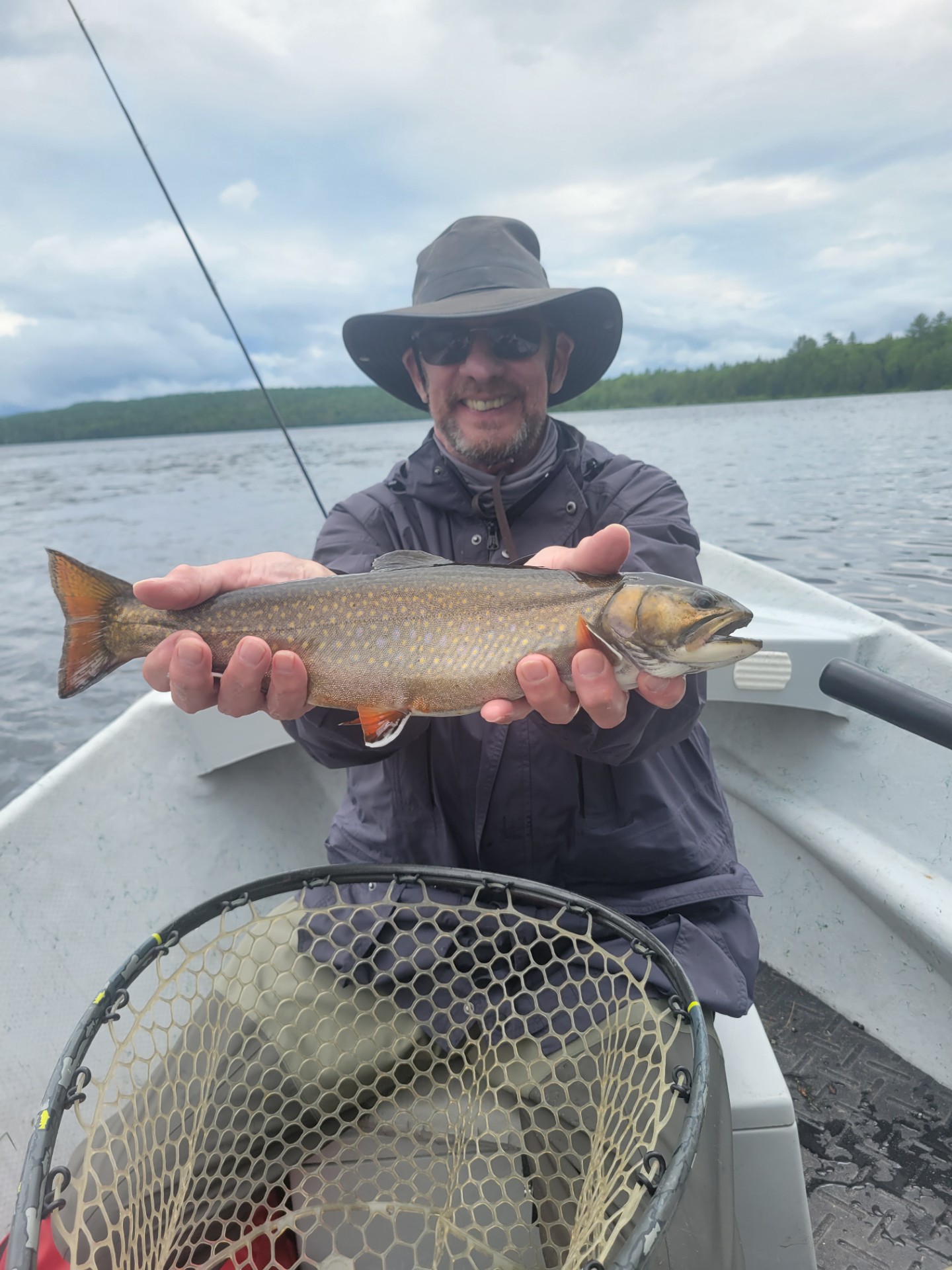 Man sitting in boat holding a fish