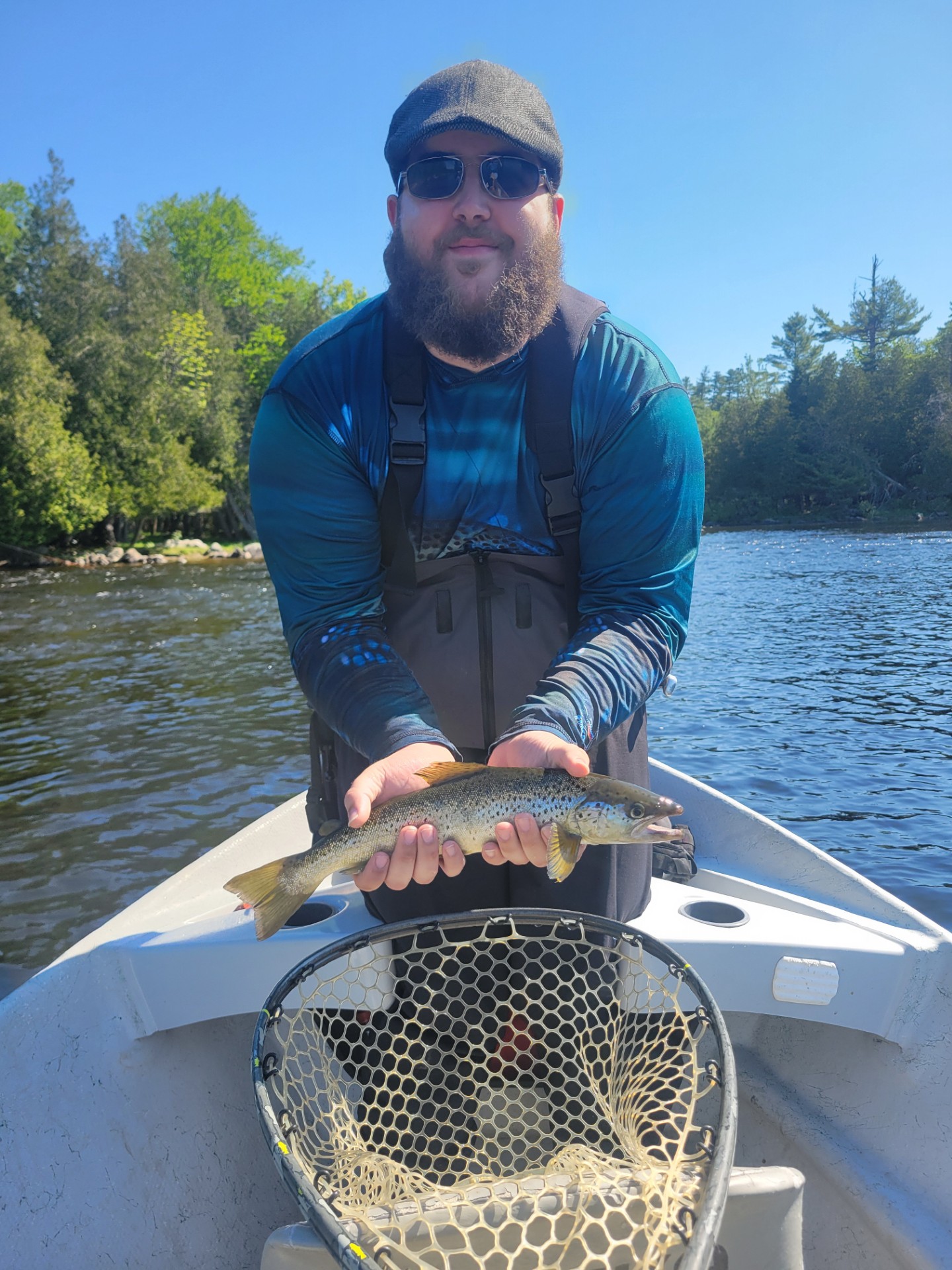 Fisherman sitting in a boat holding a fresh caught fish