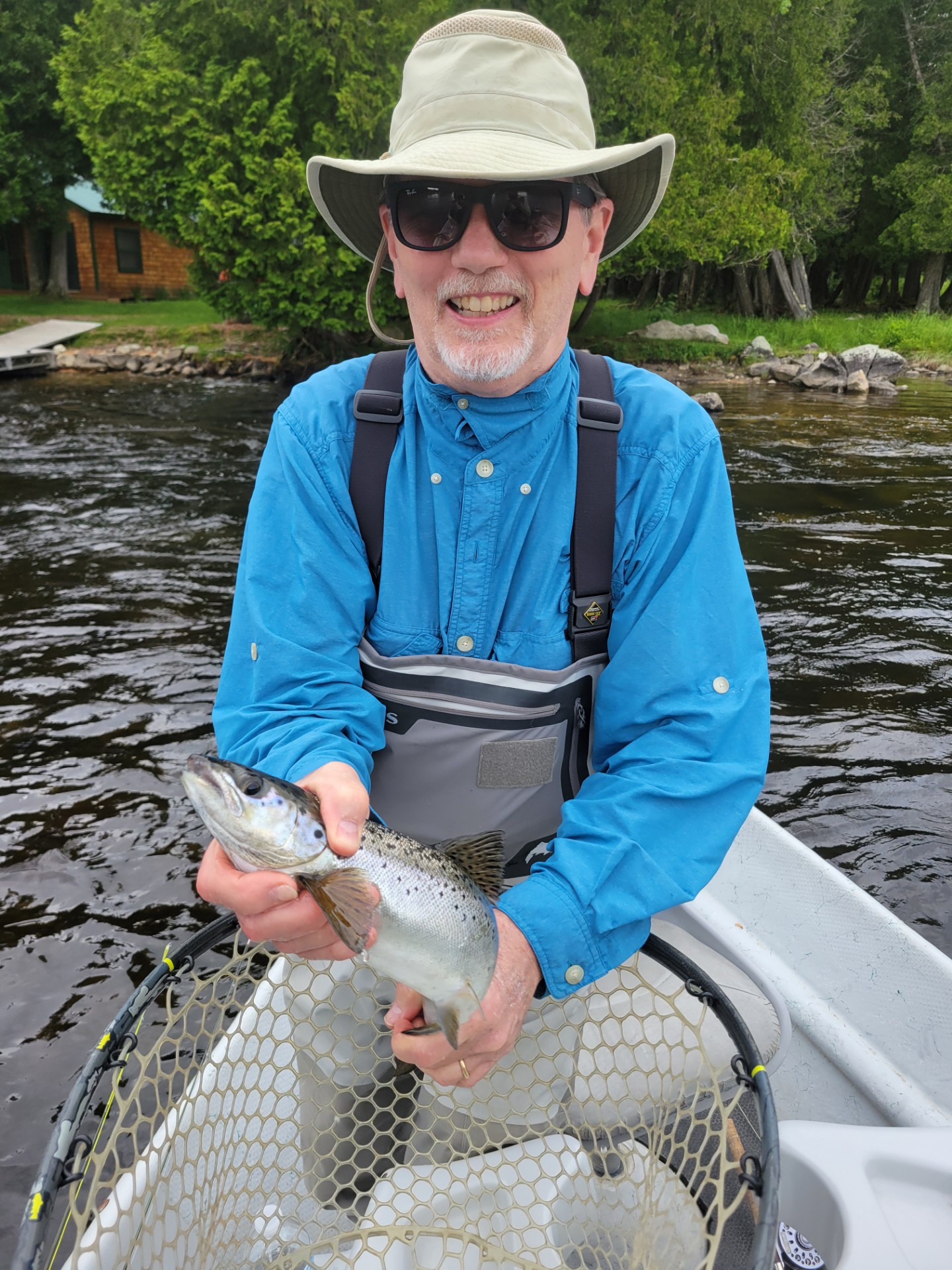 Fisherman in a boat holding a fresh caught fish