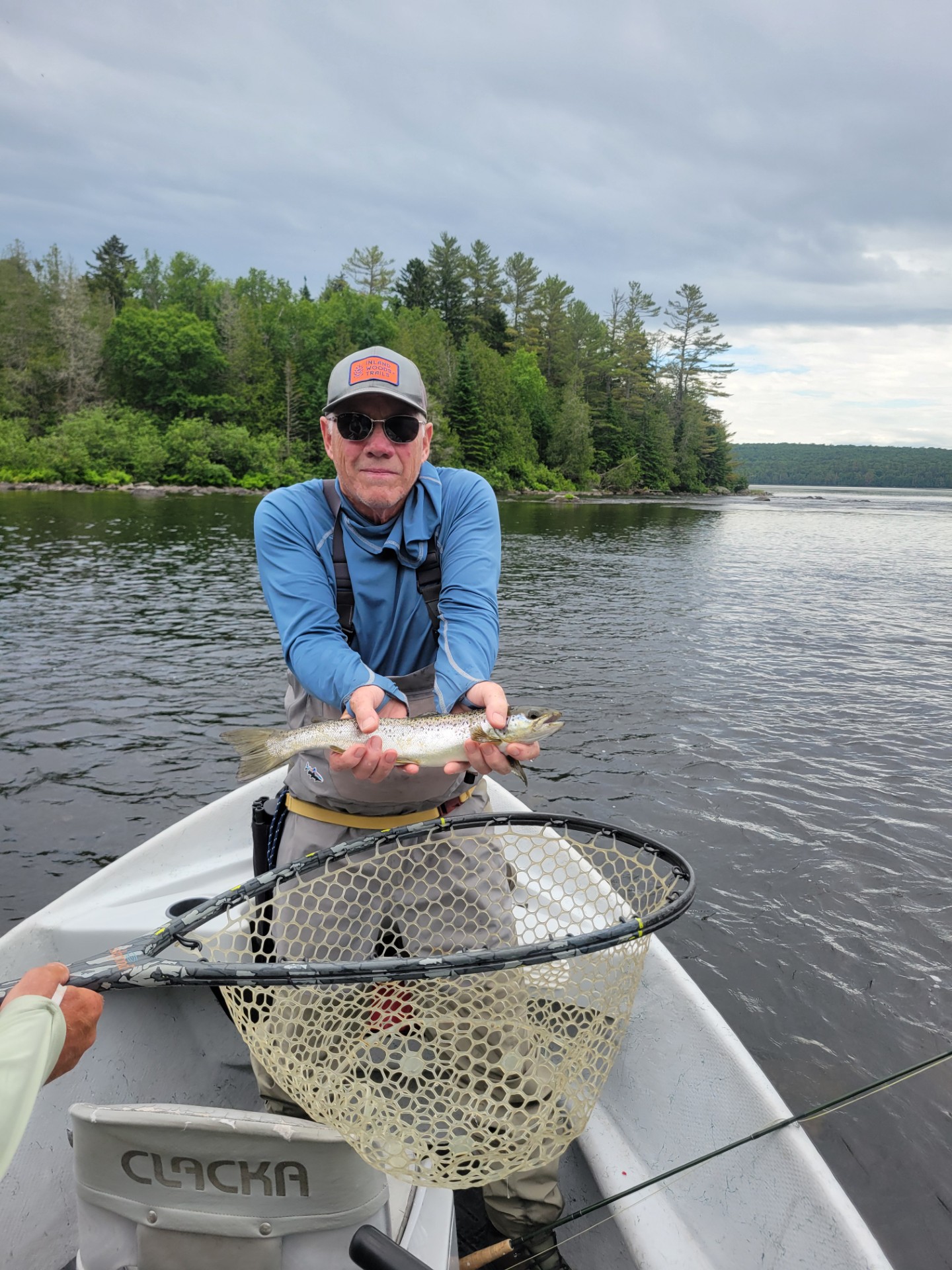 Fisherman in a boat holding a fresh caught fish